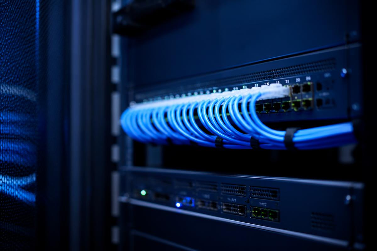 Switch de rede empresarial com cabos de fibra azuis num bastidor moderno